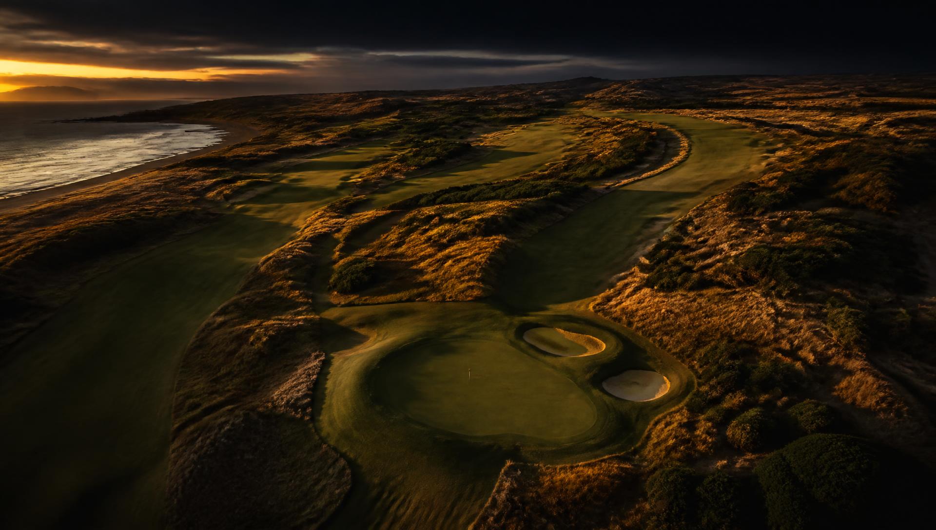 Aerial view of a coastal golf course at dusk